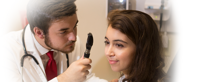 doctor checking his standardized patient's eye