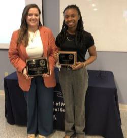 Olivia Pickett and Marissa Hall stand side by side holding their plaques