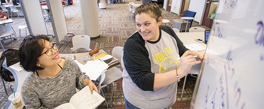 Students working together at a white board in the Marx library