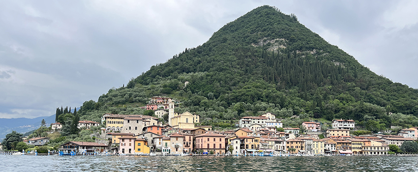 Mountain with houses in front of it and lake in Northern Italy.