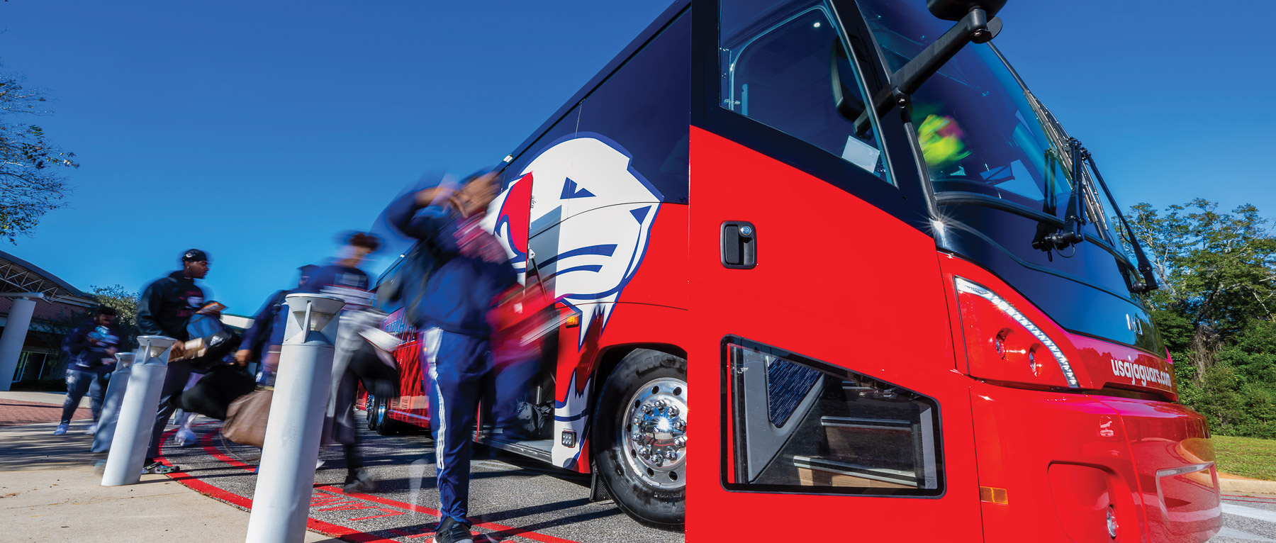 Four red and blue coach buses play an integral role in transporting University of South Alabama athletics teams. The buses are also used to transport high school students to campus for Jag Days tours. 